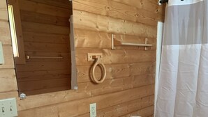 Un baño con paneles de madera, un lavabo doble, tocador, inodoro y cortina de ducha.