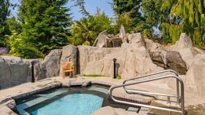 Un jacuzzi rodeado de formaciones rocosas y follaje.