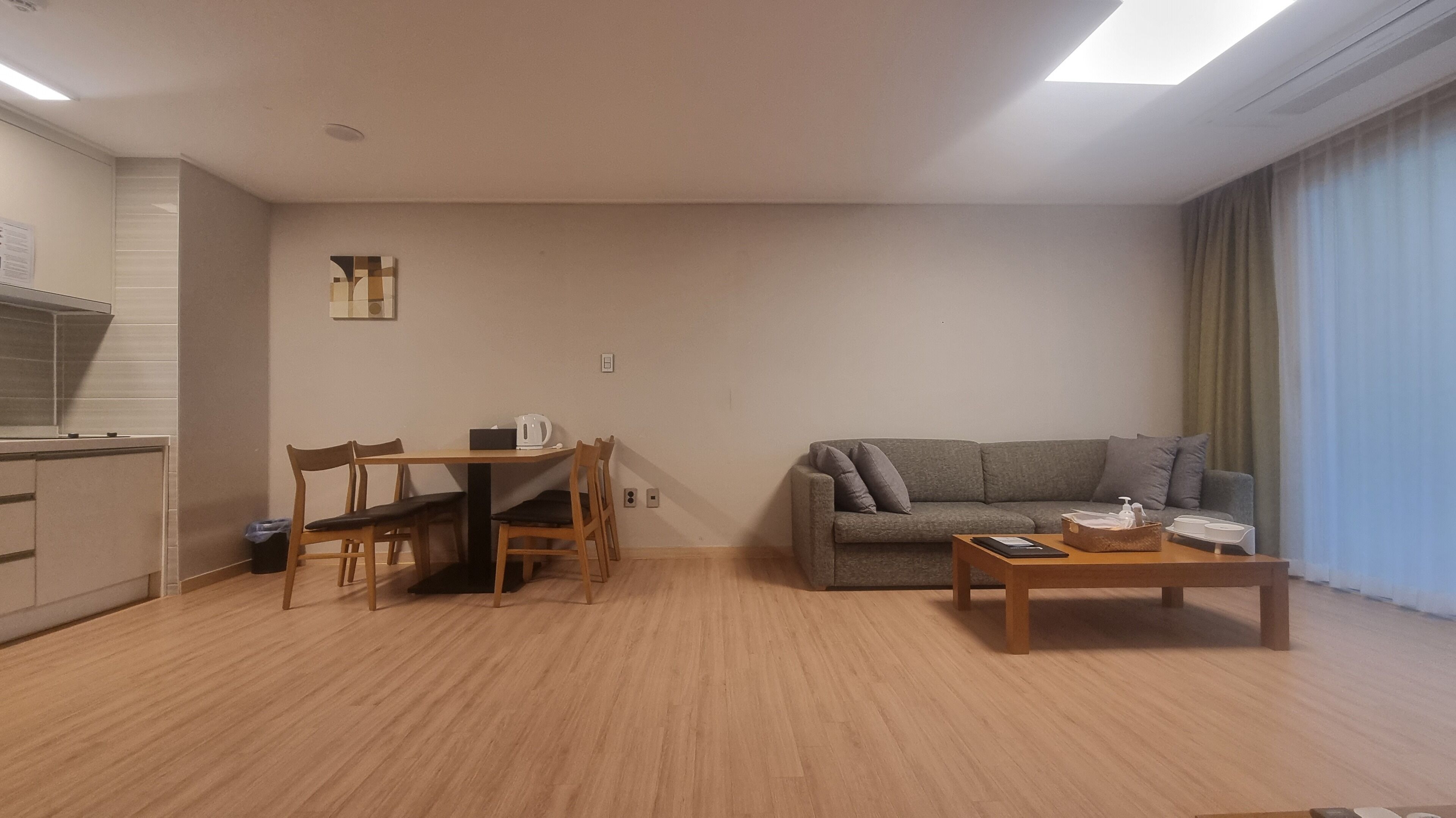 Una sala de estar moderna con un sofá, una mesa de centro y un comedor con sillas y una mesa.