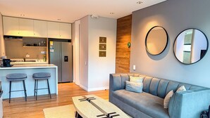 Ein modernes Wohnzimmer mit einem grauen Sofa, einem Holztisch und einem gelben Ledersessel.