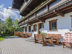 A traditional wooden building with outdoor seating and a stone-paved patio. - Holiday home on former farm (Brixen im Thale)