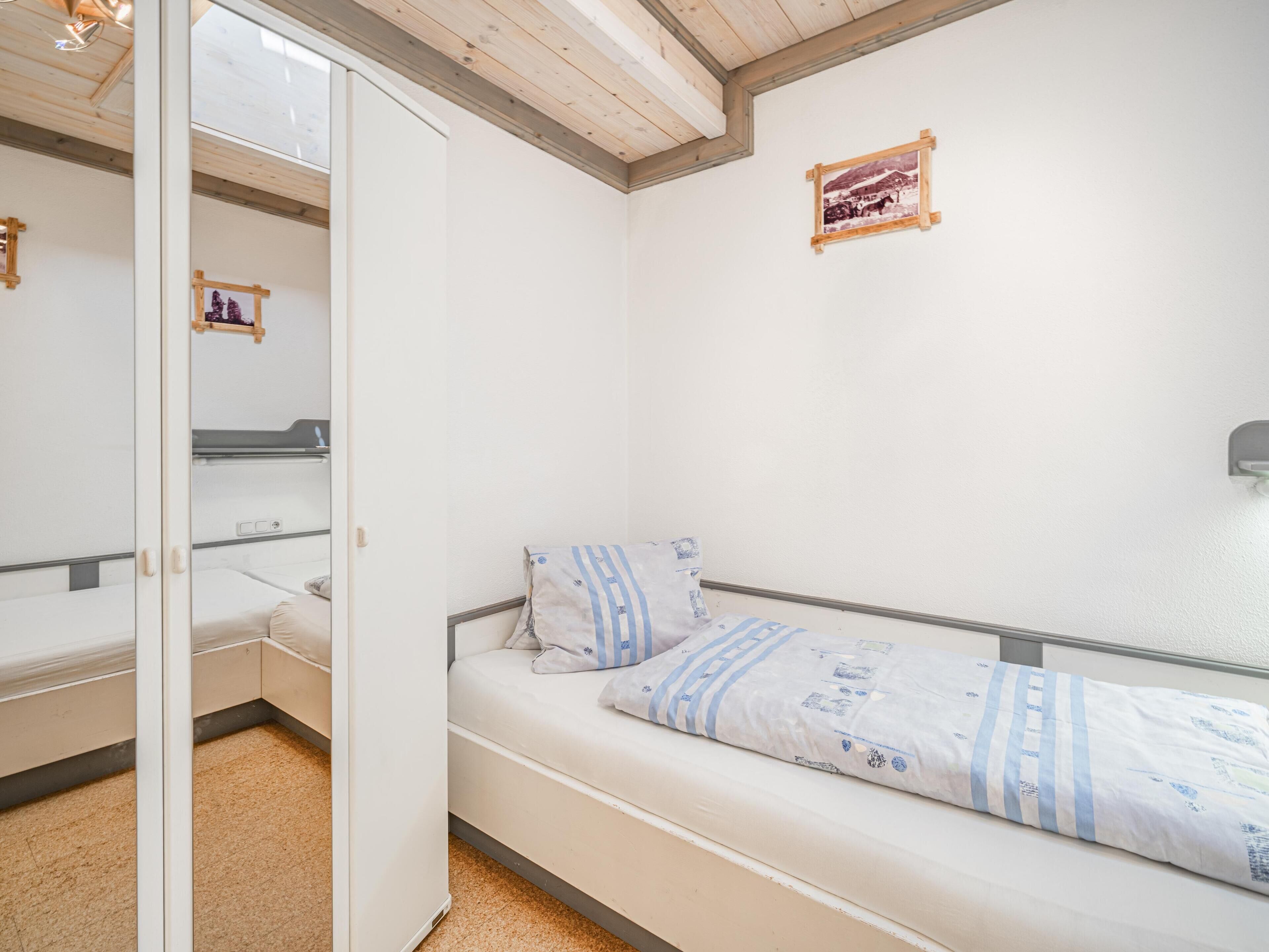 Une chambre à coucher avec un lit, une armoire et un miroir.