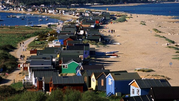 Et kystområde med farverige strandhytter og en sandstrand.