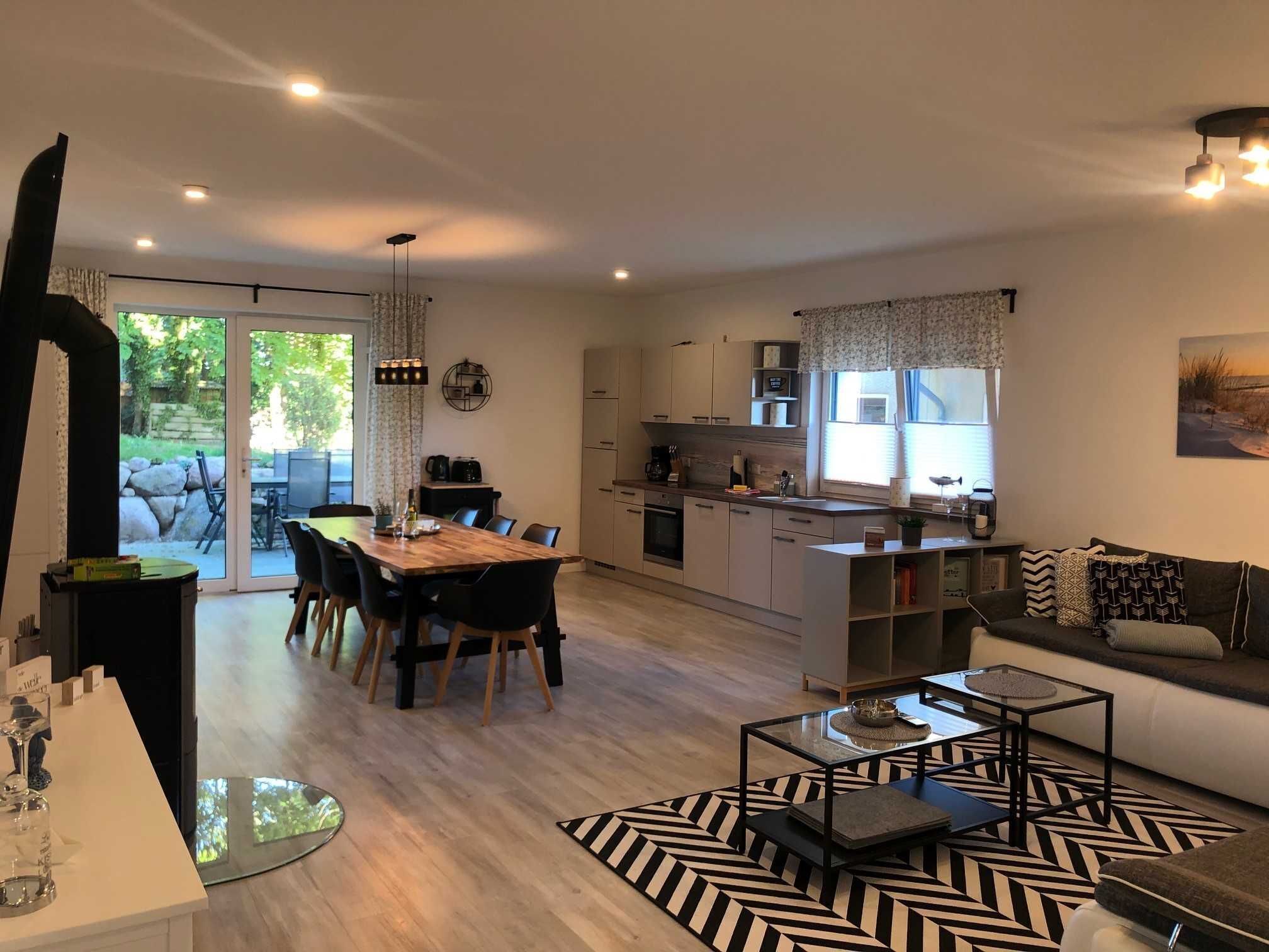 Una sala de estar moderna con sofá, mesa de centro y comedor.