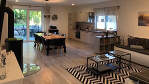 Una sala de estar moderna con sofá, mesa de centro y comedor.