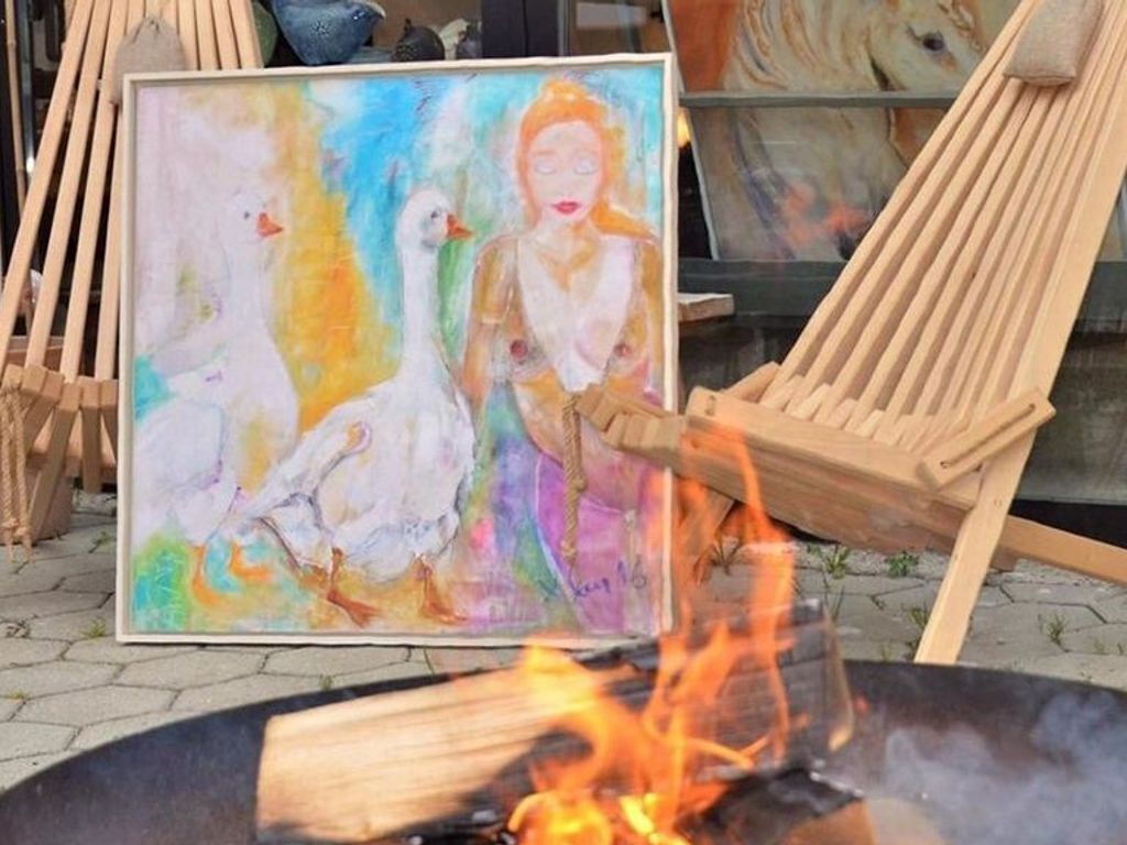 A painting on a wooden easel, a fire pit, and a hammock.