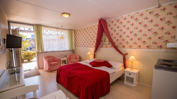 A bedroom with a bed, a desk, a chair, a TV, and a window. - Apartment Süd Terasse 45m² (Rømø)