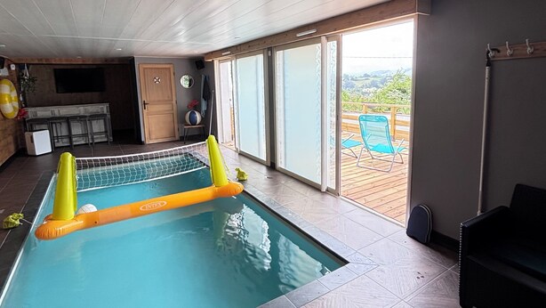 An indoor swimming pool with a view of the outdoors, a ceiling with recessed lighting, and a tiled floor. - Large atypical house in the Basque country, sleeps 16. Indoor pool (Ayherre)