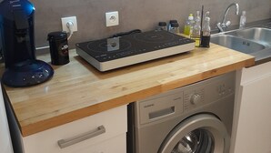 A kitchen with a coffee maker, a kettle, a toaster, and a washing machine. - Le Pastre (Montpeyroux)