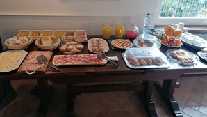 Un bufé de desayuno con diversas opciones de comida y bebidas.