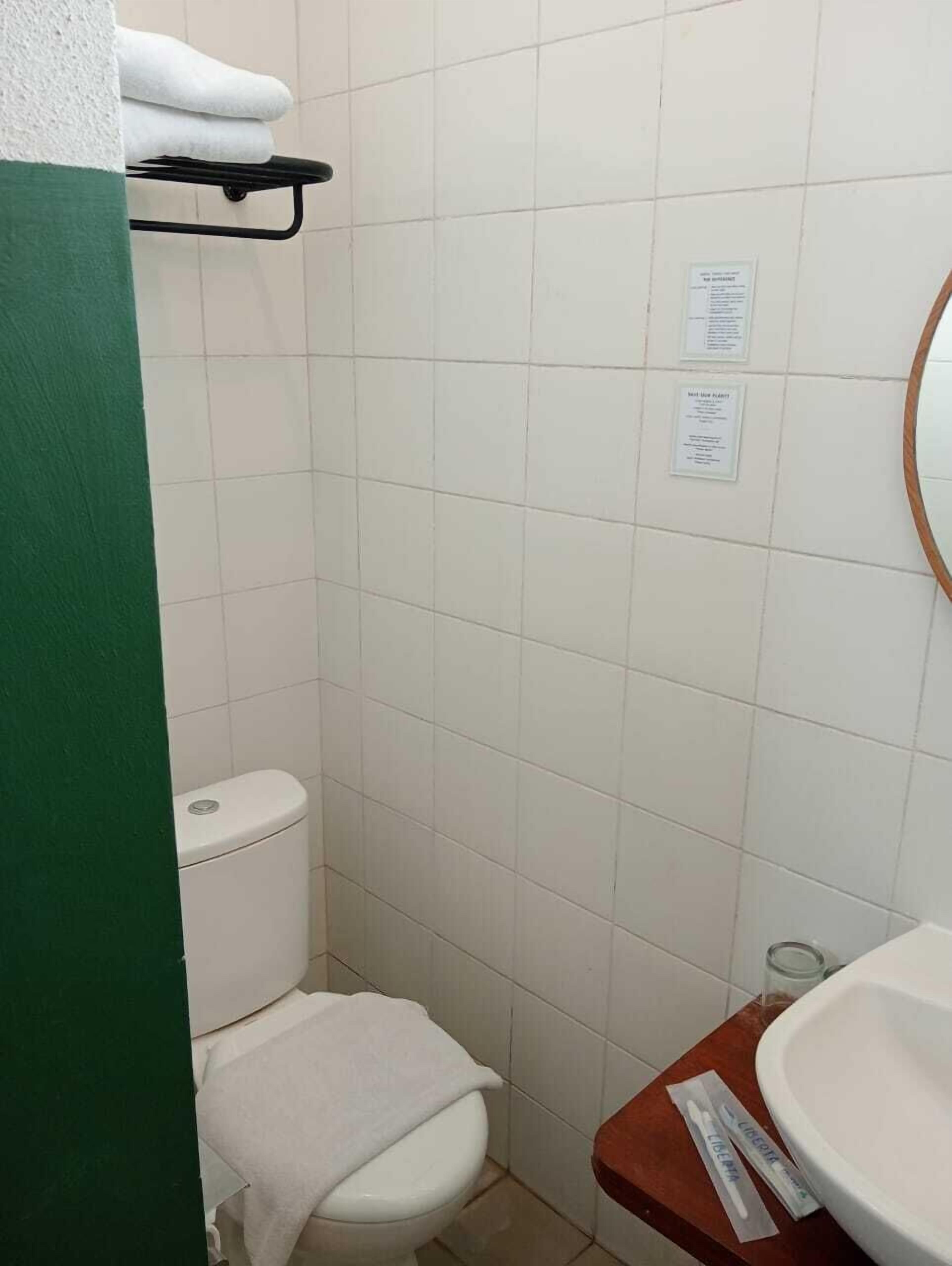 A small, clean bathroom with a toilet, a sink, and a towel rack.
