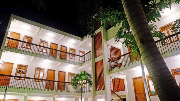 A multi-story hotel with balconies, wooden doors, and a central staircase. - Liberta Malioboro South (Yogyakarta)