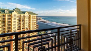 Un hotel con varios balcones con vistas a una playa y al océano.