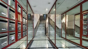 Ein Flur mit Briefkästen und einer Treppe, die zu einer anderen Etage führt.