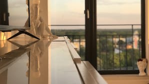 A modern interior with a reflective surface, a sculpture, and a view through large windows.