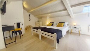 Un dormitorio con cama, escritorio, silla, cómoda y mesita de noche.