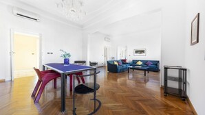 A spacious living area with a dining table, chairs, a sofa, and a coffee table. - GetTheKey appartamento Quadrilatero (Bologna)