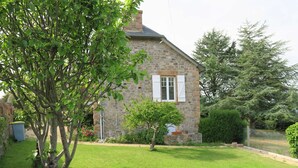 A stone house with a well-maintained lawn and a small tree in the foreground. - Renovated house 100m from sea with WIFI, garden in Trégastel (Trégastel)