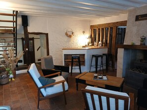 Un salon chaleureux avec une cheminée, un bar et un espace détente.