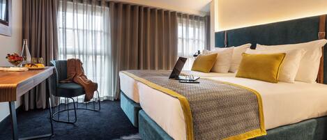 A hotel room with a bed, a desk, and a chair.