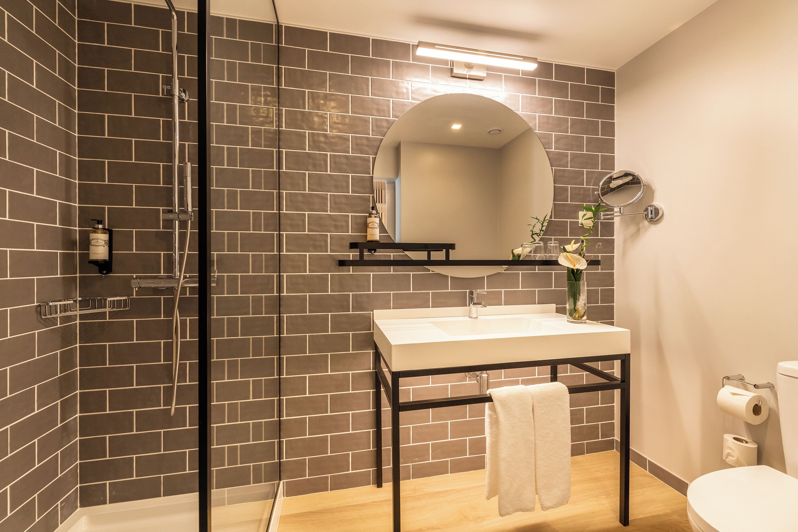 Un baño moderno con ducha, lavabo e inodoro.