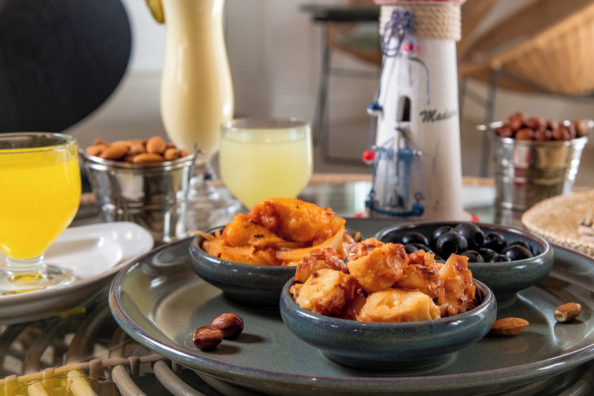 A breakfast setting with bowls of food, a glass of orange juice, and a coffee maker.