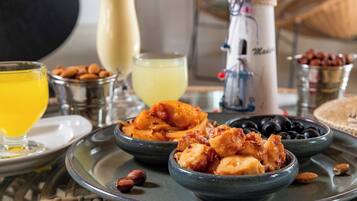 A breakfast setting with bowls of food, a glass of orange juice, and a coffee maker.