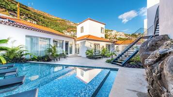 Alberca al aire libre y camastros