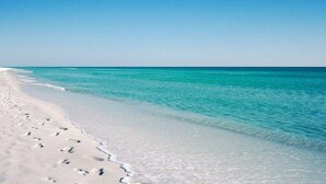 Una playa con agua turquesa cristalina y arena blanca.