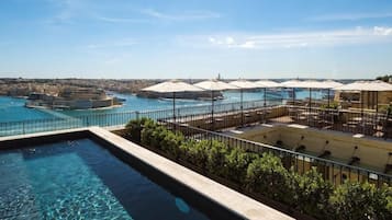 Una piscina cubierta, una piscina al aire libre, tumbonas