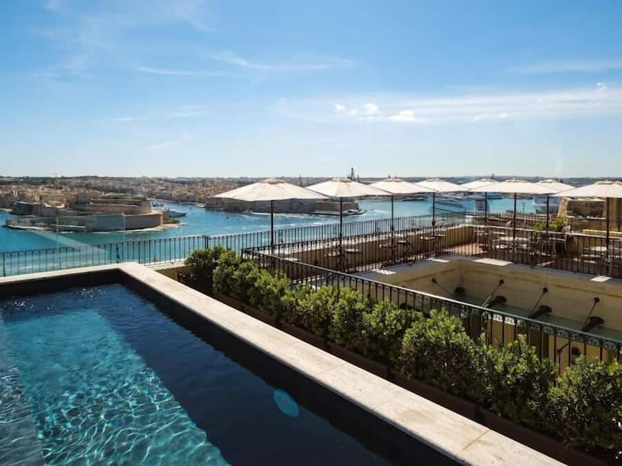 Een binnenzwembad, een buitenzwembad en ligstoelen