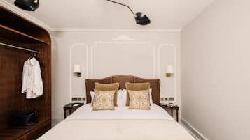Une chambre d’hôtel avec un grand lit, une armoire en bois et deux lampes de chevet.
