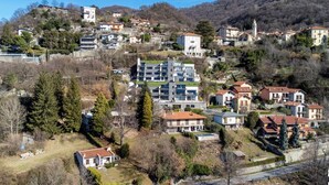 A hillside residential area with modern and traditional houses, a church, and a prominent tower. - In a panoramic position, modern apartment on the first floor of a new residence with SPA. Large windows frame the unique landscape of Lake COMO.This apartment has a beautiful terrace, with table and chairs and a sofa. The living room is a large open spac (Perledo)