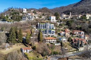 Un quartier résidentiel situé sur une colline, avec des maisons modernes et traditionnelles, une église et un imposant édifice.