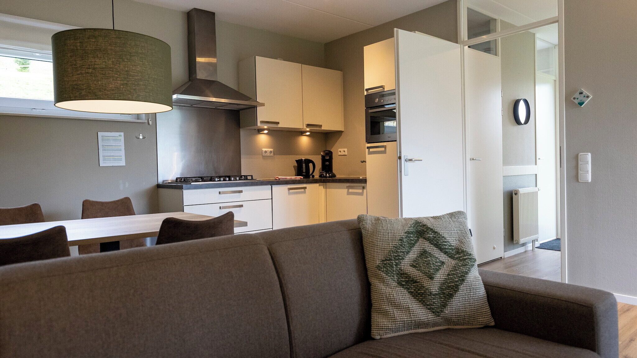 Un espace de vie compact comprenant un canapé, une table à manger et un coin cuisine.