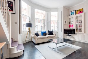 Comfort-Apartment (1 Bedroom) | Wohnzimmer | 35-Zoll-Fernseher mit Kabelempfang, Bücher