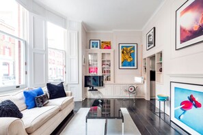 Comfort Apartment (1 Bedroom) | Living room | 35-inch TV with cable channels, books