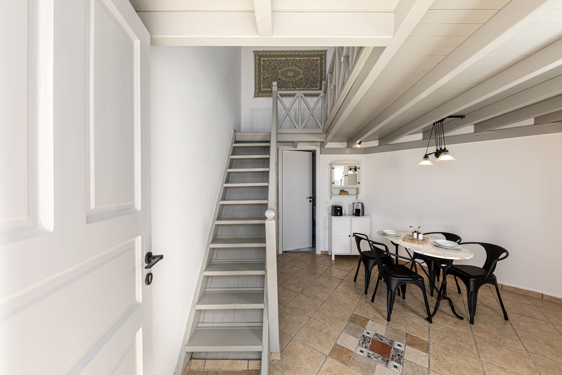 A staircase leading to a loft bedroom with a view of the city.