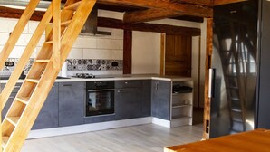 Une cuisine moderne dotée d’une cuisinière, d’un four et d’un réfrigérateur noirs intégrés.