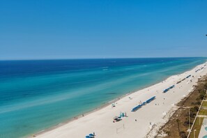 A beach with clear turquoise waters, a long stretch of sand, and a pier in the distance. - Tower 2, 1 bedroom!!! FREE BEACH CHAIRS!!! (Panama City Beach)