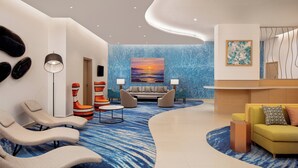 Eine moderne Lobby mit blauem Teppich, einem Empfangsbereich und Sitzgeboten.