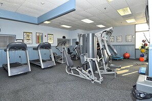 Academia com esteiras, aparelhos de musculação e bolas de exercício.