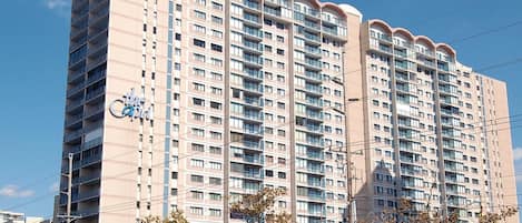 A high-rise hotel with multiple balconies, a prominent sign, and a clear sky.