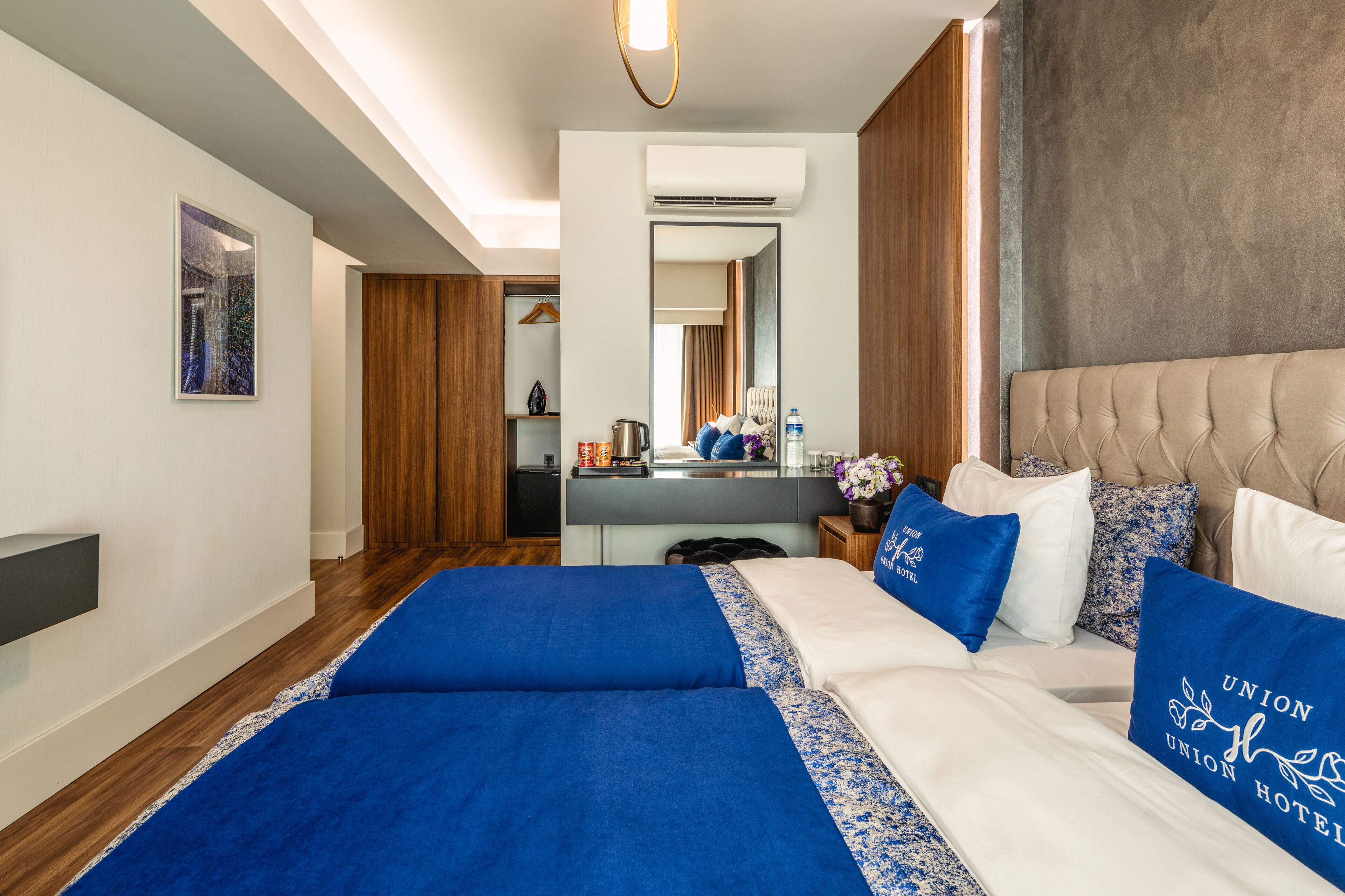 Une chambre d’hôtel avec un grand lit, une table de chevet, un miroir et une armoire.