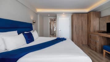 Une chambre d’hôtel moderne avec un grand lit, une armoire en bois et un bureau avec une chaise.