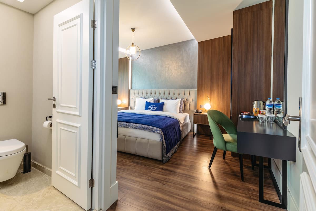 Ein Hotelzimmer mit Bett, Schreibtisch, Stuhl, Badezimmer und Tür.