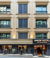 A hotel with multiple balconies, a coffee shop at the ground level, and a sign reading "Union Hotel Coffee and More".