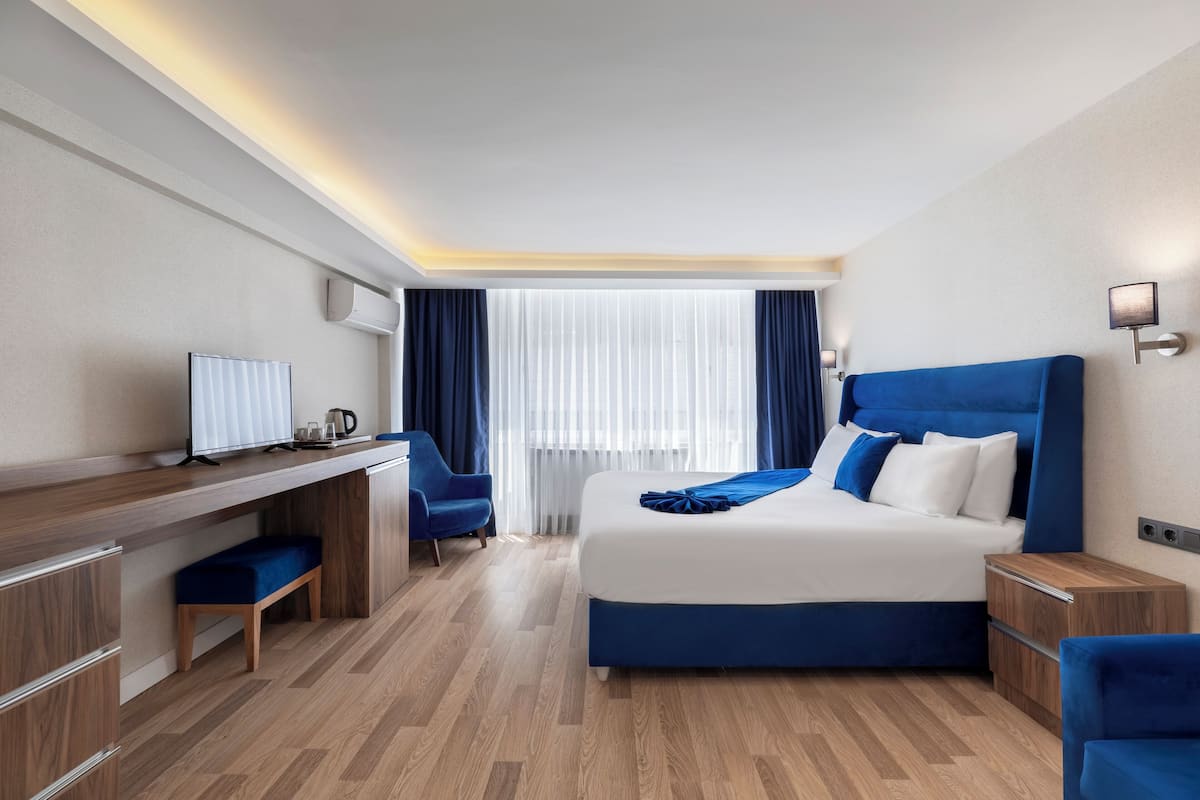 Ein modernes Hotelzimmer mit einem großen Bett, einem Schreibtisch und einem Stuhl.