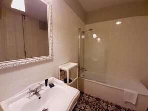 Ein Badezimmer mit einer Badewanne, einer Dusche und einem Waschbecken.