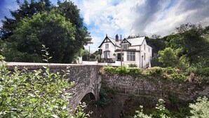 Un edificio blanco tradicional con un puente de piedra al frente.